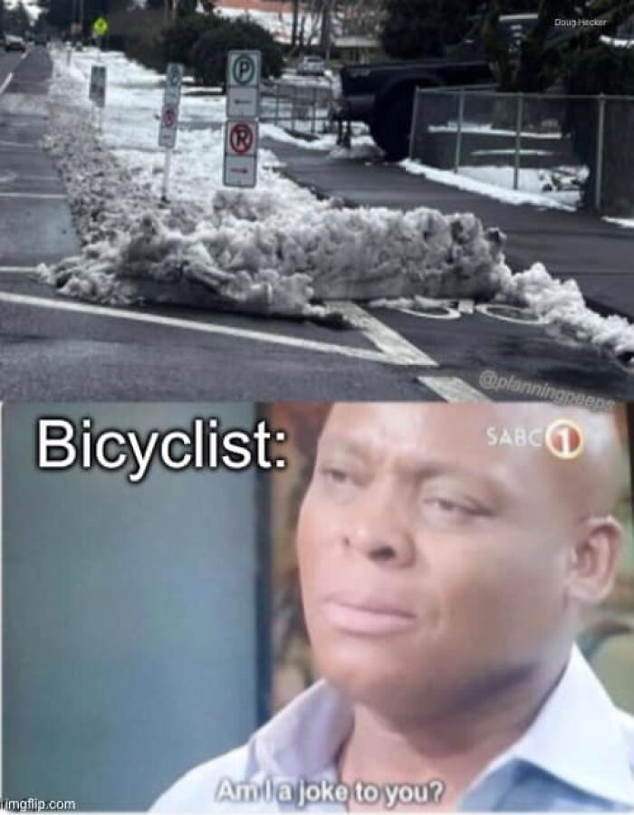 Snow blocking a bike lane with a meme questioning modern city planning absurdity.