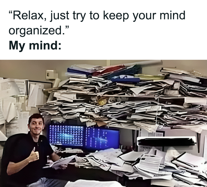 Man smiling at cluttered desk, symbolizing mental health chaos in a humorous meme setting.