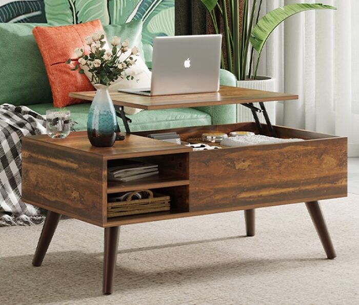 Wooden coffee table with a lift-top, laptop, and plants, perfect addition to shopping lists for home decor updates.