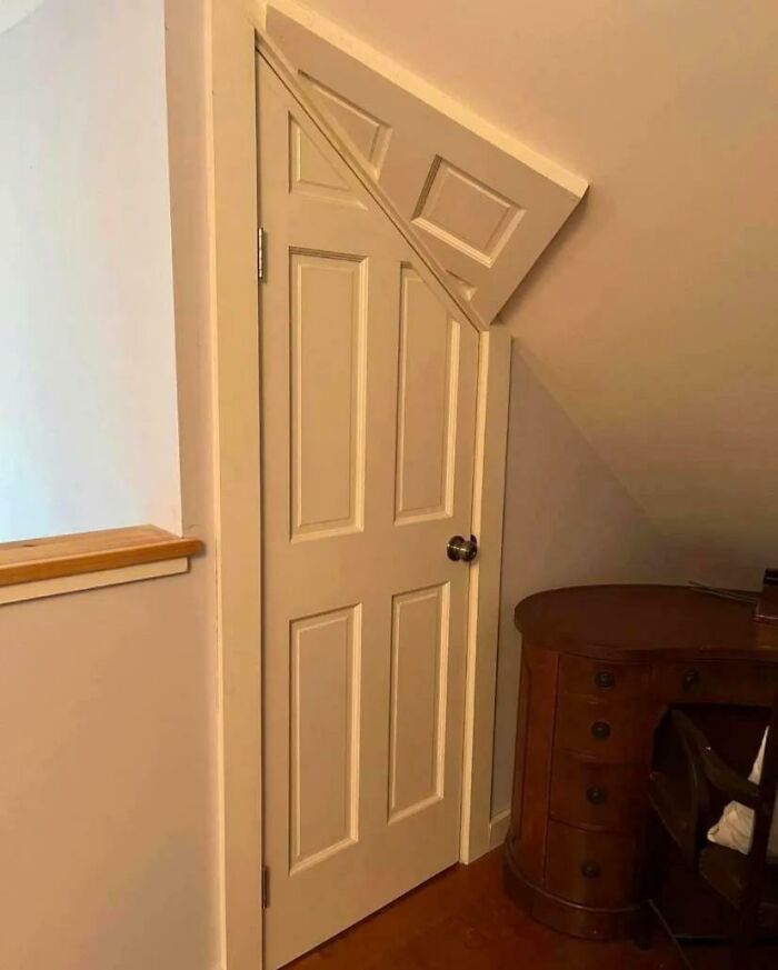 Door cut with a smaller door piece at the top, showcasing a DIY disaster in a home interior beside a wooden desk.