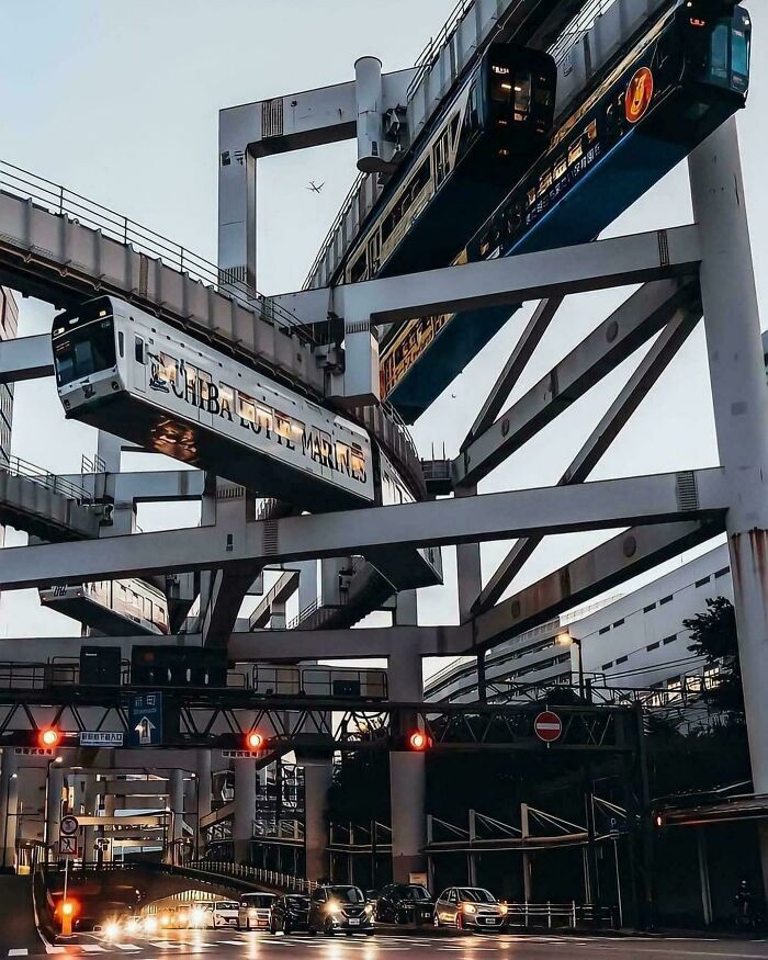 Suspended monorail trains passing on elevated tracks in an urban setting showcasing brilliant infrastructure design.