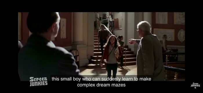 An older man pointing at a child in a museum, discussing complex dream mazes.