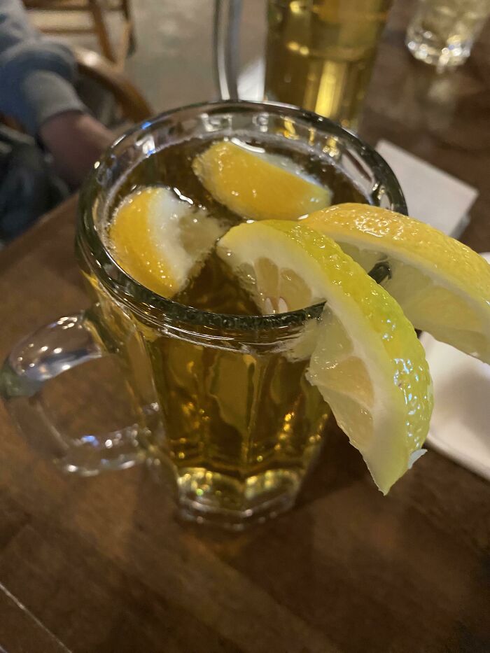 A mug of beer with extra lemon slices from a food service request.