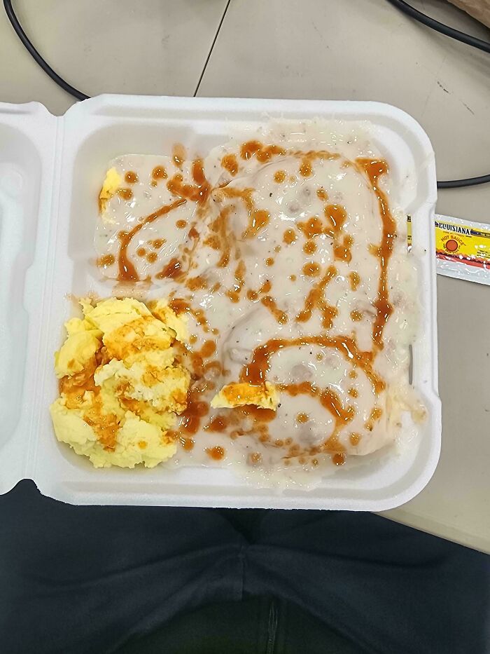 Takeout box with mashed potatoes and gravy, showcasing a generous response to customer's extra request in food service.