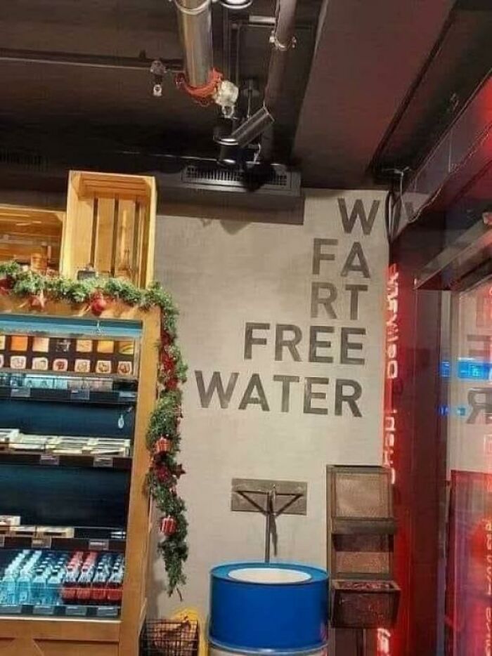 Sign fail in store reads "WAT FREE WATER," accidentally spelling "FART" vertically.