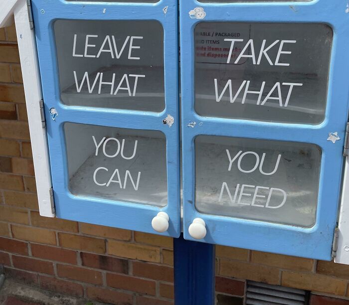 Blue donation cabinet with confusing sign reading, "Leave what you can, take what you need." Sign fails message.