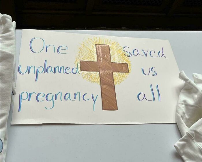 Sign fail showing message about unplanned pregnancy with a drawing of a cross in the center.