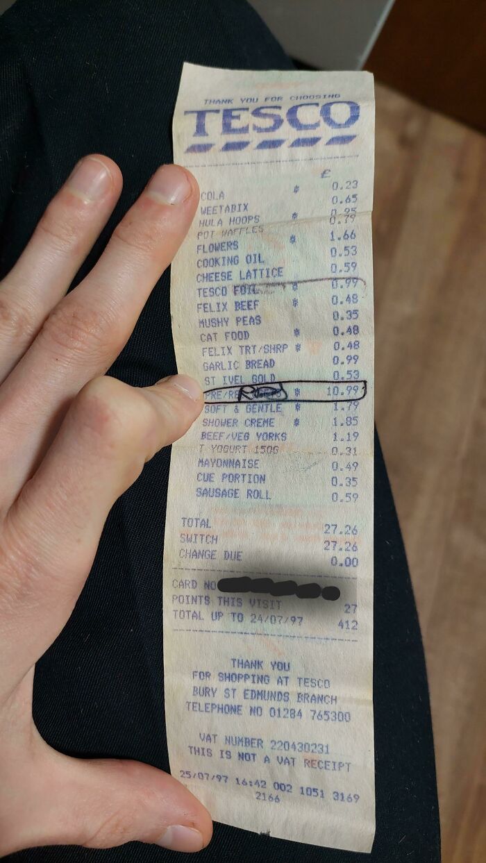 A vintage Tesco receipt held by a person, showcasing delightfully British shopping items.