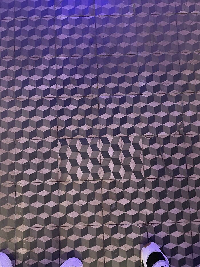 Geometric floor pattern with a mismatched tile, illustrating a classic "you had one job" fail.