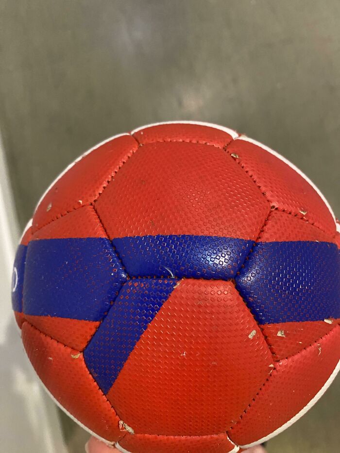 A red soccer ball with a misaligned blue stripe, illustrating a funny fail.