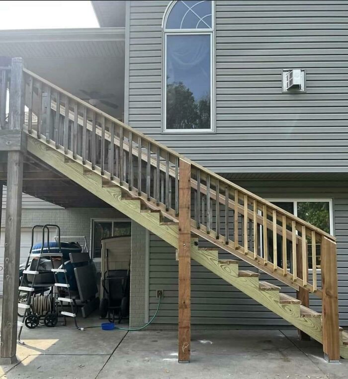 Stairs built directly in front of a window, showcasing a classic "you had one job" fail.