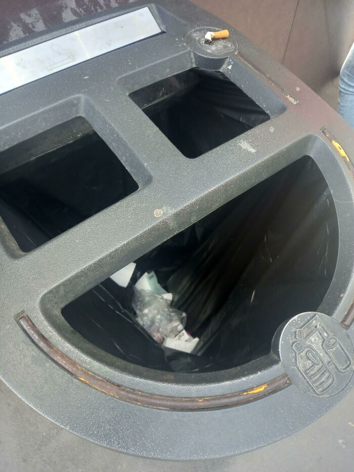 Trash bin fail with misplaced cigarette disposal spot.