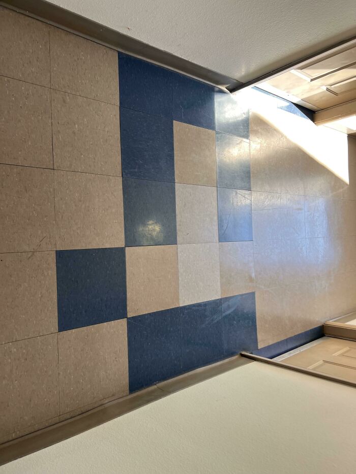 Checkerboard floor pattern with one tile misplaced, illustrating a job fail.