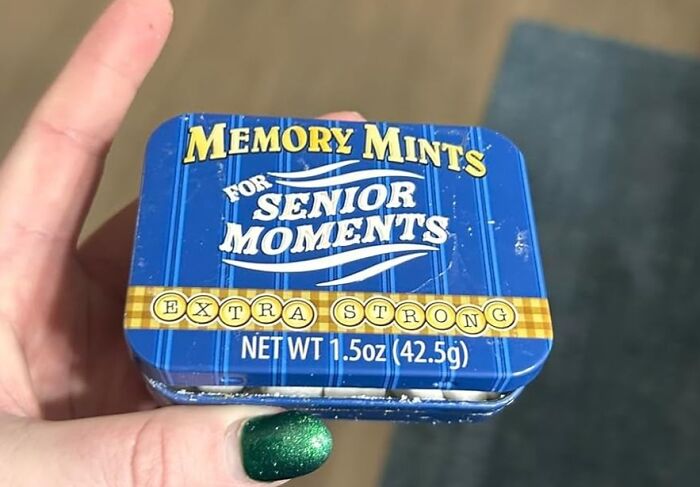 Hand holding a tin of funny memory mints, a humorous Mother's Day gift for senior moments, with a blue striped design.