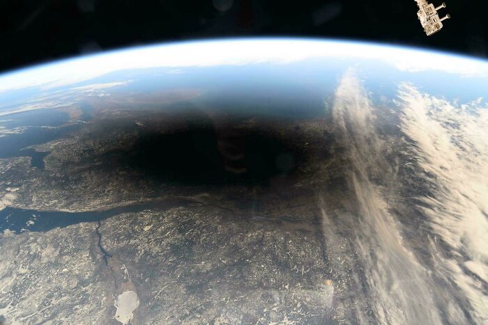 Vista desde el espacio mostrando un eclipse sobre la Tierra, destacando cómo la naturaleza sorprende desde las alturas.