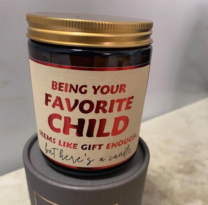 Funny Mother's Day gift candle with "Being your favorite child" label in bold red text on beige jar.