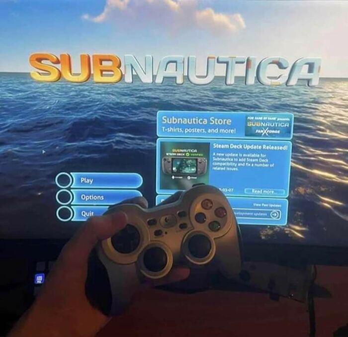 Game controller in hand, Subnautica screen in background, sparking curiosity.