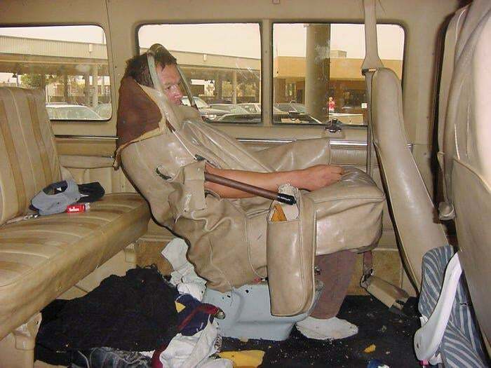 Man disguised as a car seat, blending into a vehicle interior to creatively cheat the system.