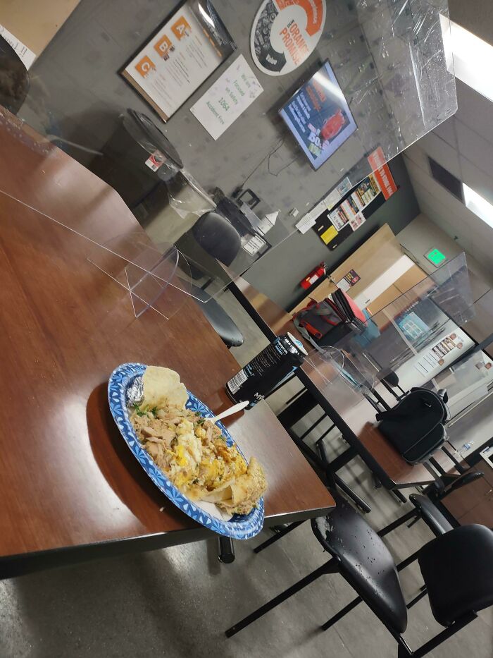 A tray of food on a break room table, surrounded by empty chairs, highlighting clever system evasion.