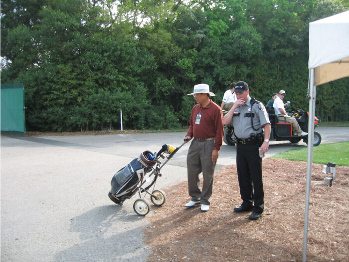 Man with golf cart and security guard at a golf course, illustrating acting like they belong in an unexpected setting.