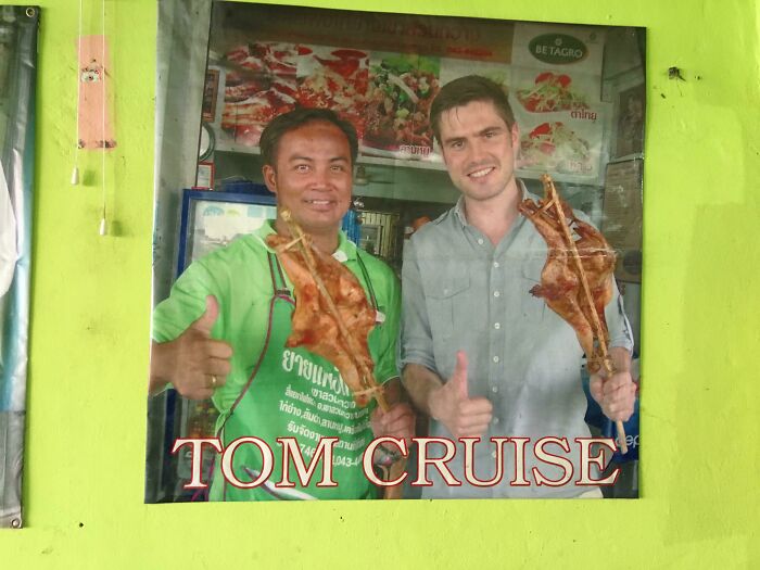 Two men smiling and holding roast meat, with a green wall background and humorous text overlay.