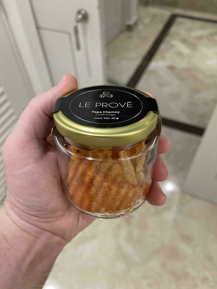 A hand holding a jar of Le Prove Papa Chamoy chili chips, an unusual snack dish.