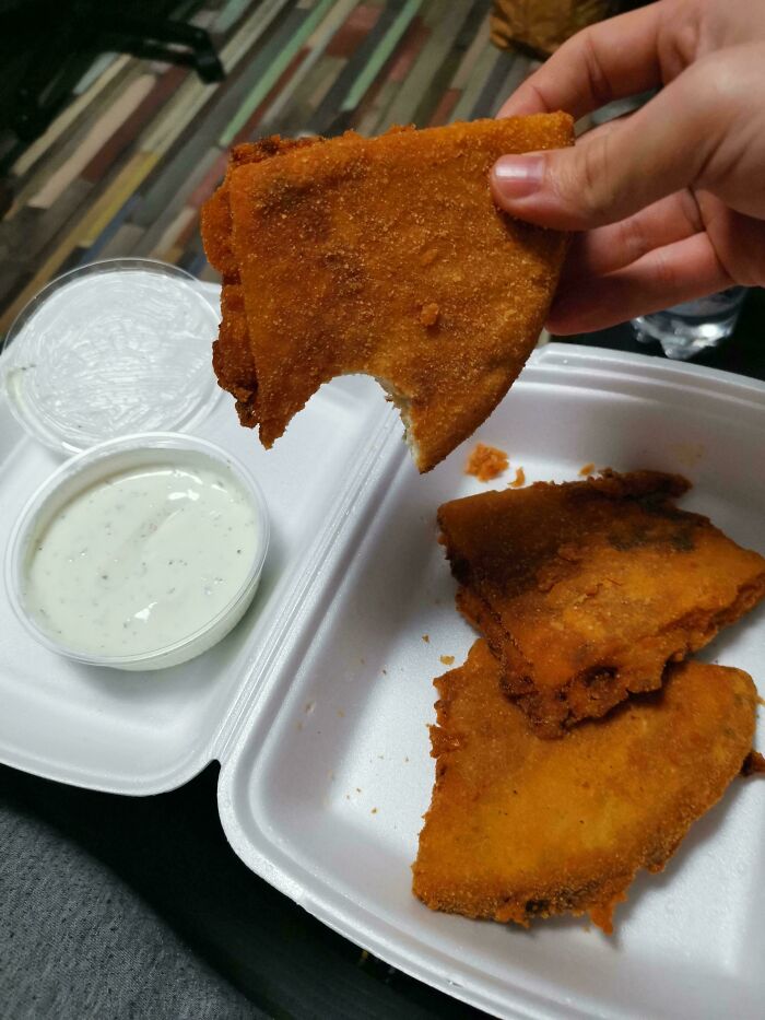 Breaded fried food in a takeout container with dipping sauces, an example of unusual dishes.