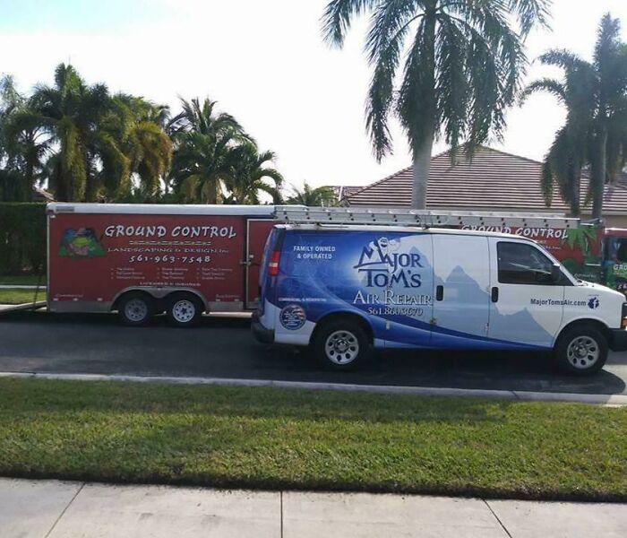 Coincidence photo showing a van and trailer with matching company names Major Tom and Ground Control parked near palm trees.