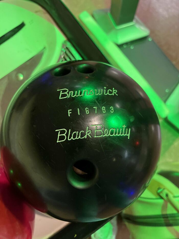 Black Brunswick bowling ball named Black Beauty, captured as a wild coincidence photo by a bowling alley visitor.