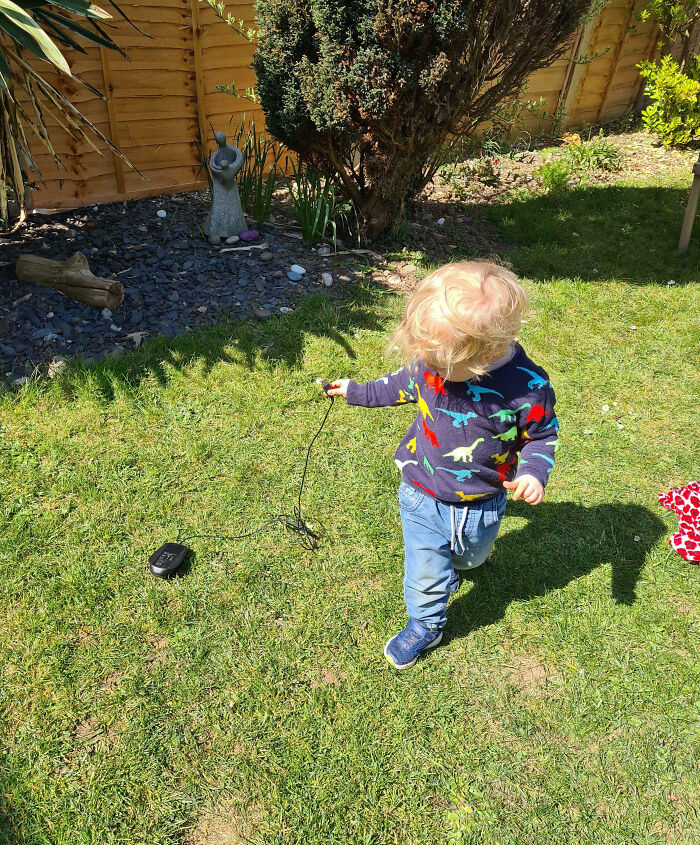 Mi hijo llevando su ratón de paseo por el jardín