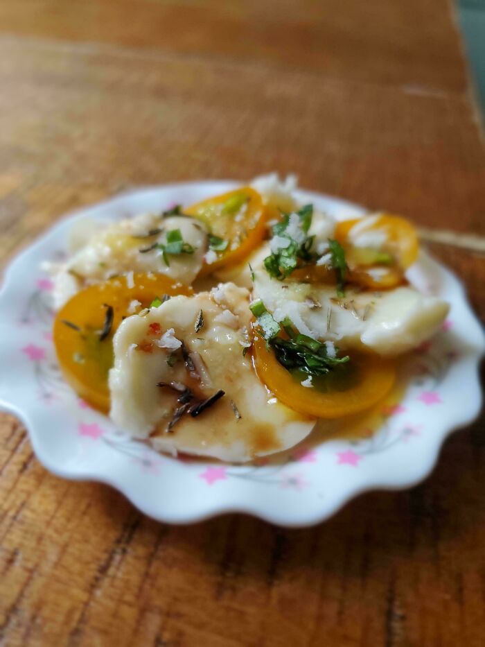 Plate of sliced tomatoes with herbs and cheese, capturing a humorous harvest presentation.
