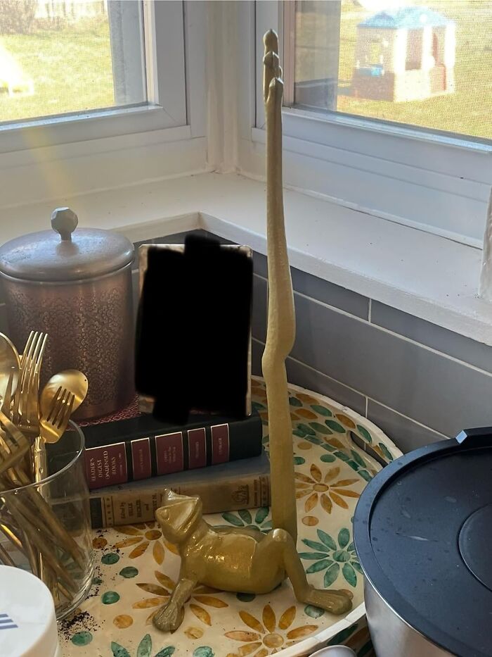 Golden frog and tall skinny figure on kitchen counter near window, part of awesome shopping list items.