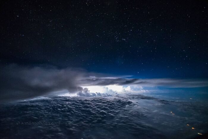 Aerial photo of night sky with stars and clouds illuminated from below, showcasing breathtaking aerial photography by pilot.