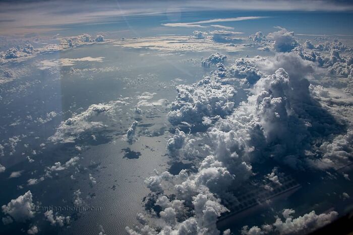 Aerial photo from a pilot showing vast ocean and dramatic cloud formations under a bright sky.