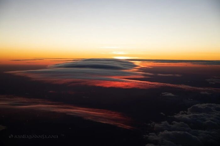 Aerial photo of a colorful sunset sky with layered clouds showcasing breathtaking views captured by a pilot in flight.