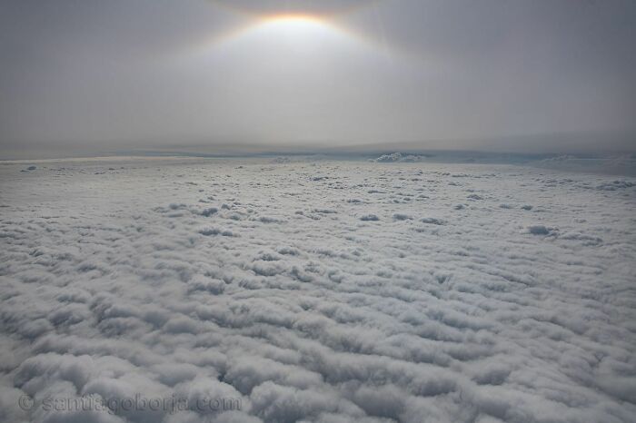 A breathtaking aerial photo showing a vast cloudscape beneath bright, diffused sunlight captured by a pilot in flight.