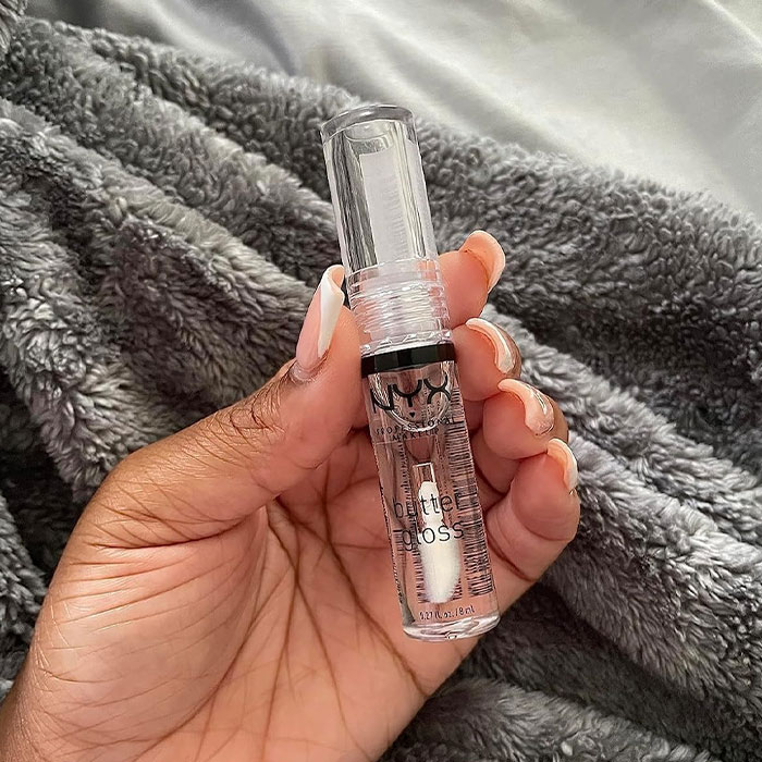 Woman holding NYX Butter Gloss, a cheap and cheerful Mother's Day gift.
