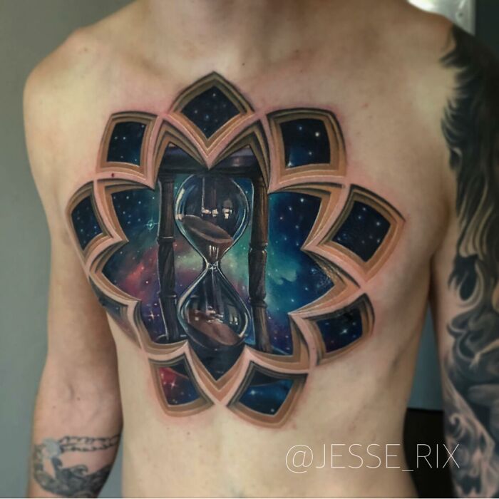 Tattoo of a galaxy-themed hourglass on chest, showcasing a world within the skin.