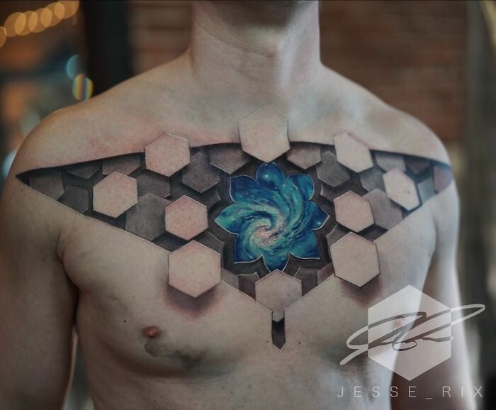 Mind-bending tattoo of a 3D hexagonal pattern revealing a galaxy on a man's chest.