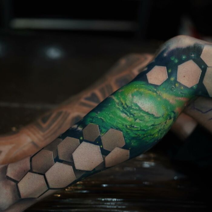 Tattoo with hexagon pattern and vibrant galaxy design, showcasing a world within the skin.