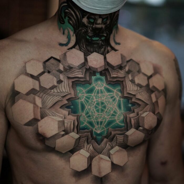 Chest tattoo featuring 3D geometric design, creating a mind-bending world within the skin with intricate details.