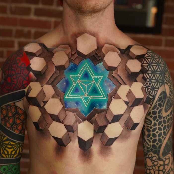 Mind-bending tattoo featuring geometric shapes with vivid colors on a person's chest and arms.