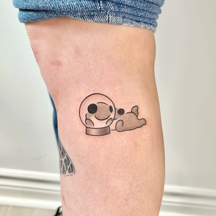 Charming tattoo by Buoy, featuring a cute snow globe and cloud design on a person's upper leg.