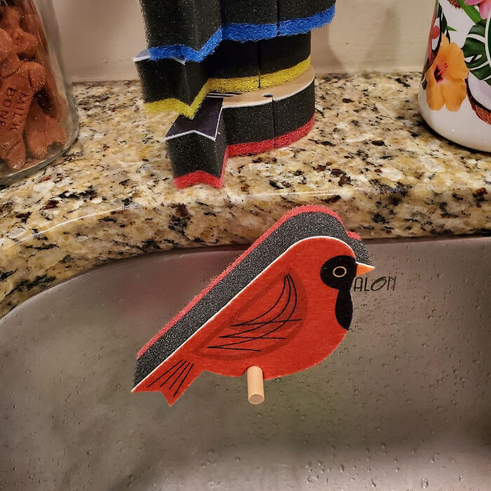 Bird-shaped kitchen sponge holder next to a sink, showcasing weird kitchen items that work.