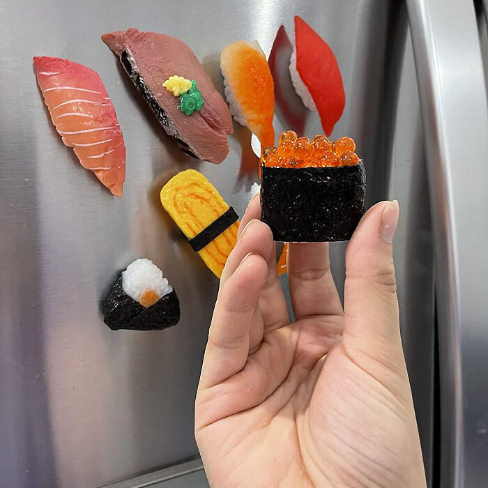 Weird kitchen item sushi magnets on refrigerator.
