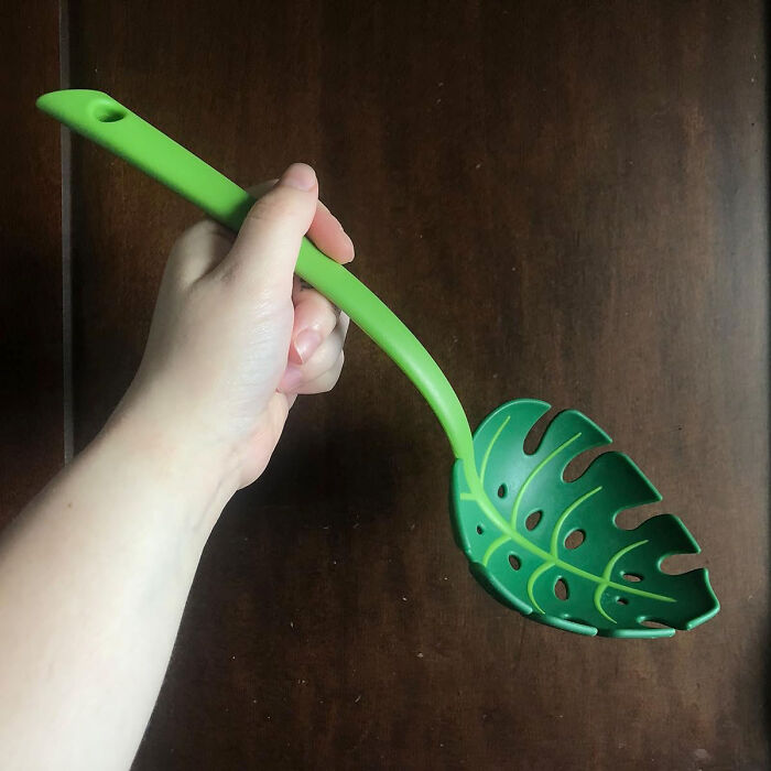 Green leaf-shaped kitchen utensil held in hand, representing a weird kitchen item that actually works.