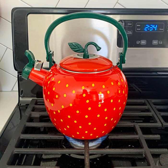 A quirky strawberry-themed kettle on a stove, showcasing one of the weirdest kitchen items that actually work.