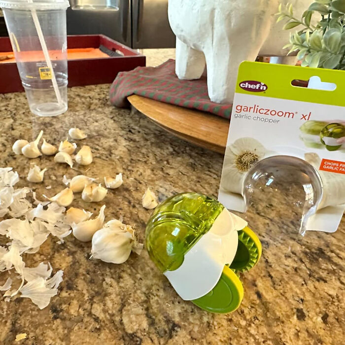 Garlic chopper on kitchen counter with garlic cloves, showcasing weird kitchen item that actually works.