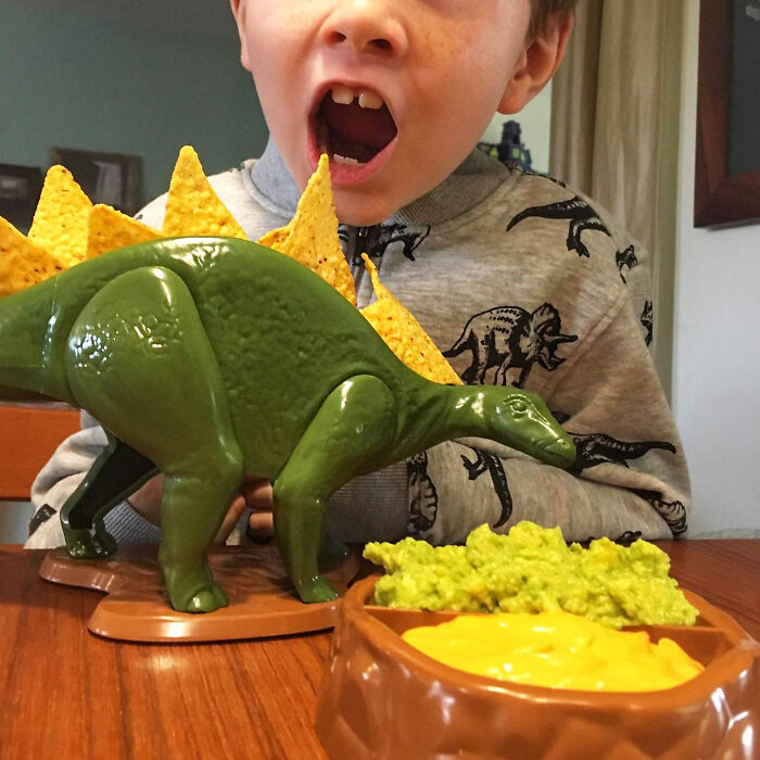 Child enjoying chips with dips served on a dinosaur-shaped tray, a weird kitchen item that works.