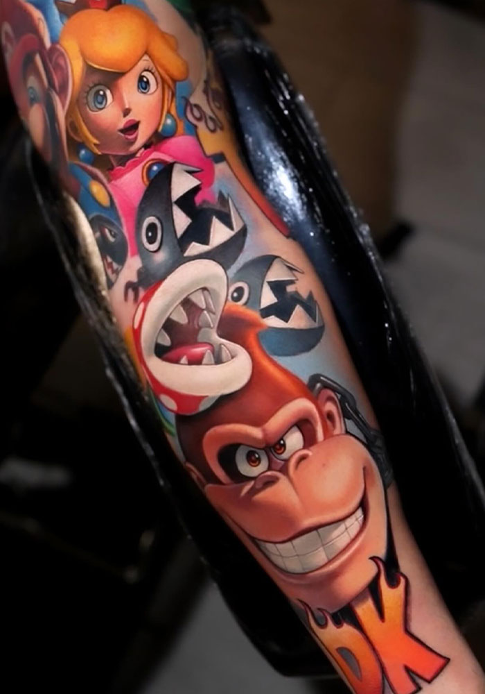 Vibrant Mario tattoo featuring Princess Peach and Donkey Kong on a person's arm.